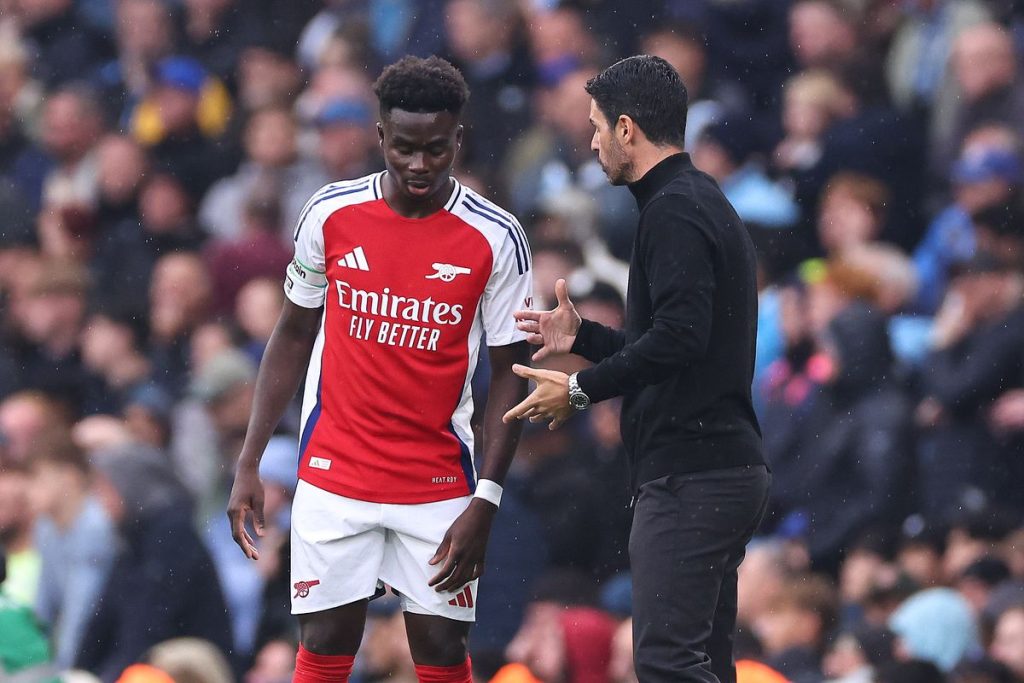 Saka and Arsenal Manager Mikel Arteta exchanging some words.